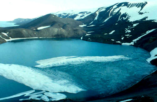 Isla volcánica de Decepción, uno de los puntos de interés científico por su latente actividad volcánica. Puede observarse el cráter, hasta donde puede navegarse a través de un pequeño estrecho llamado Fuelles de Neptuno.